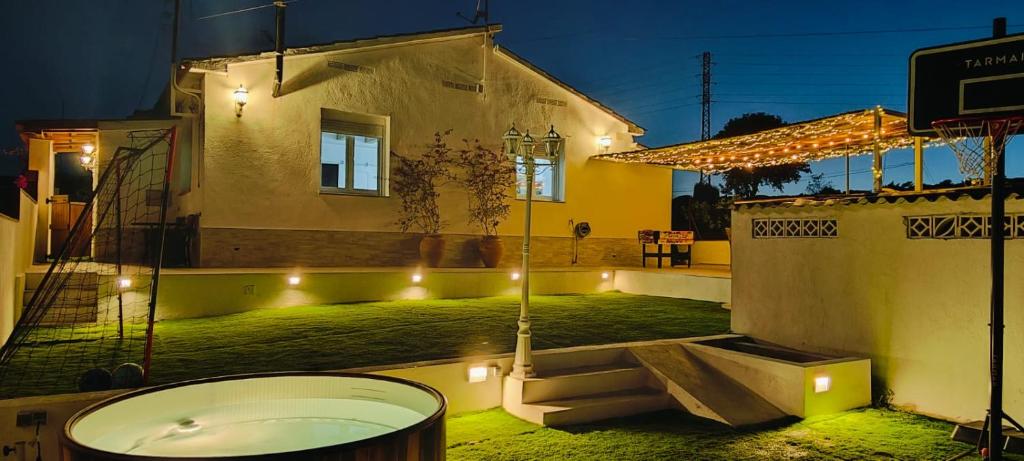una casa con bañera en un patio con luces en La Mediterranea, en Palafolls