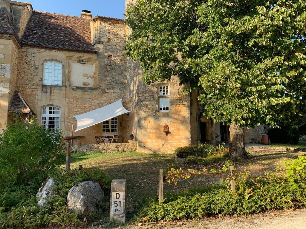 an old stone house with a sign in front of it at Château de Monsac in Monsac