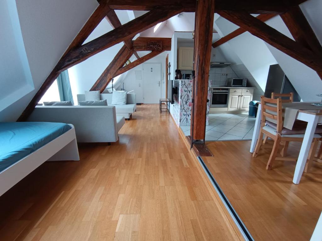 duży salon z drewnianą podłogą i poddaszem w obiekcie Dachwohnung am Schlosspark w mieście Wiesbaden