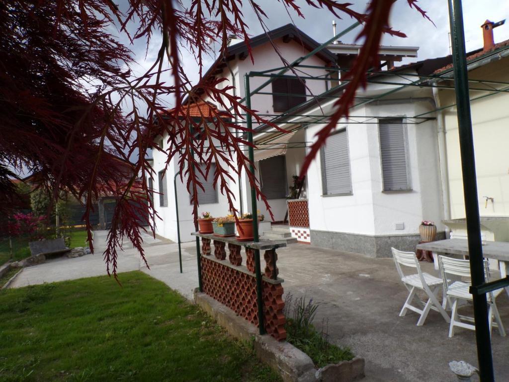 una casa con una mesa y sillas frente a ella en Casa Vacanze Terra di Mezzo, en Invorio Inferiore