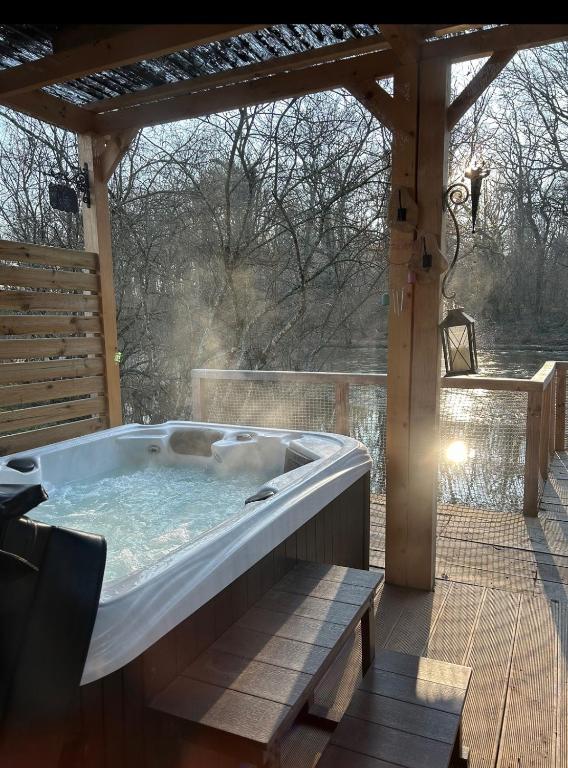 un bain à remous sur une terrasse avec pergola dans l'établissement Berry Séjours, à Malicornay