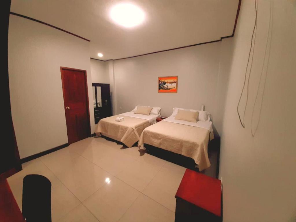a bedroom with two beds in a room at 300 RV Apartments Iquitos Peru-Apartamento tercer piso con 1 dormitorio in Iquitos