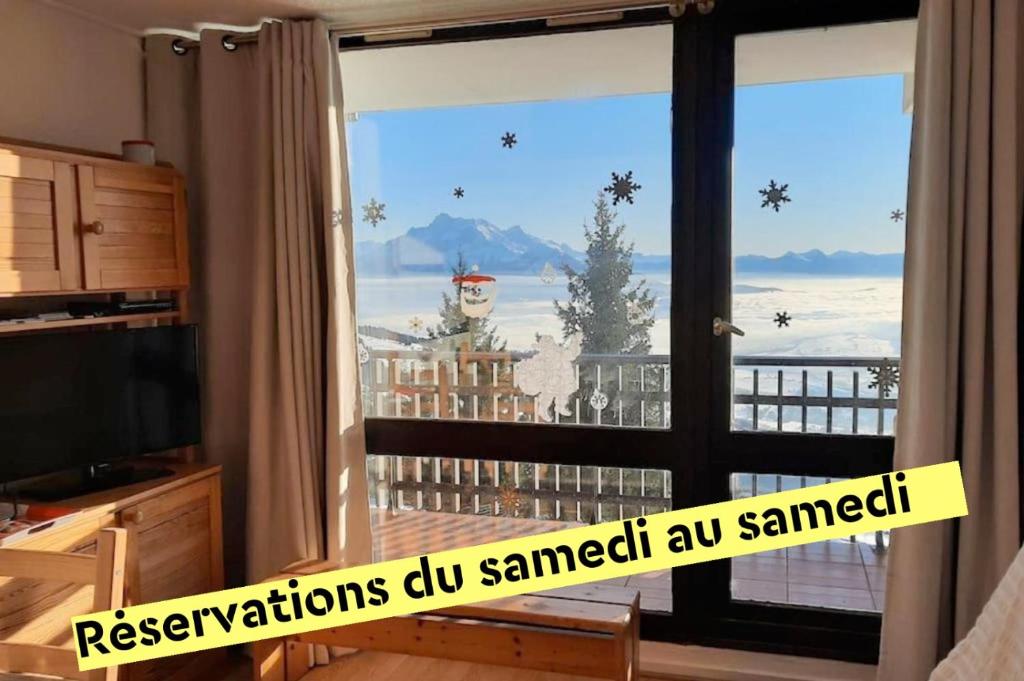 d'une chambre avec une porte coulissante en verre offrant une vue. dans l'établissement Appartement de montagne en Matheysine, à Saint-Honoré