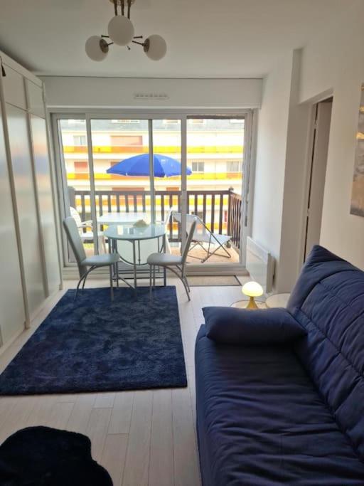 un salon avec un canapé et une table dans l'établissement Charmant studio dans résidence front de mer, à Cabourg