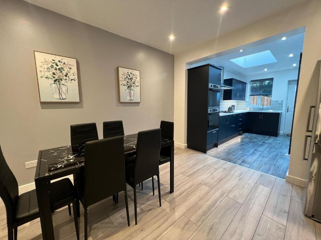 a dining room with a table and chairs and a kitchen at Cosy Budget Room in Beckenham