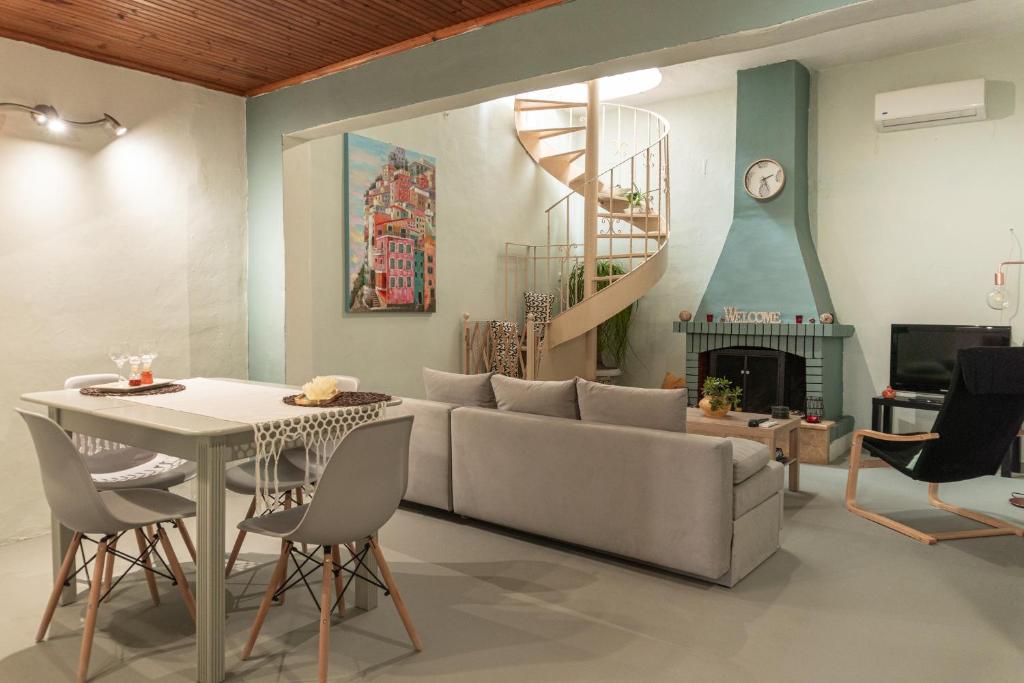 uma sala de estar com um sofá, uma mesa e uma lareira em Christine's House em Lepanto