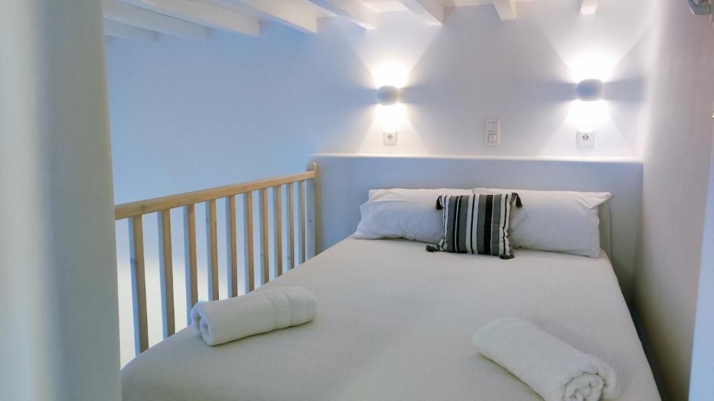 a white bed with two pillows on a crib at Rania's Home in Mikonos