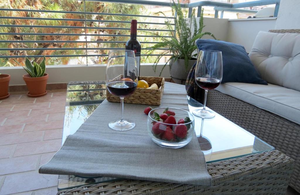 un tavolo con due bicchieri di vino e un cesto di frutta di Calm & Comfortable Studio: Central Kalamaria, Walk to the Sea + On-site Parking a Salonicco