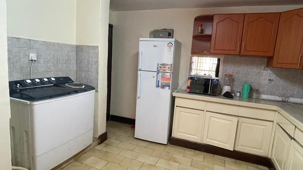 a kitchen with a white refrigerator and a stove at Riverside Villa in Nairobi