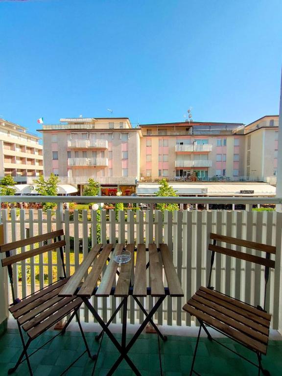 a wooden table and two chairs on a balcony at Viale Aurora in Bibione