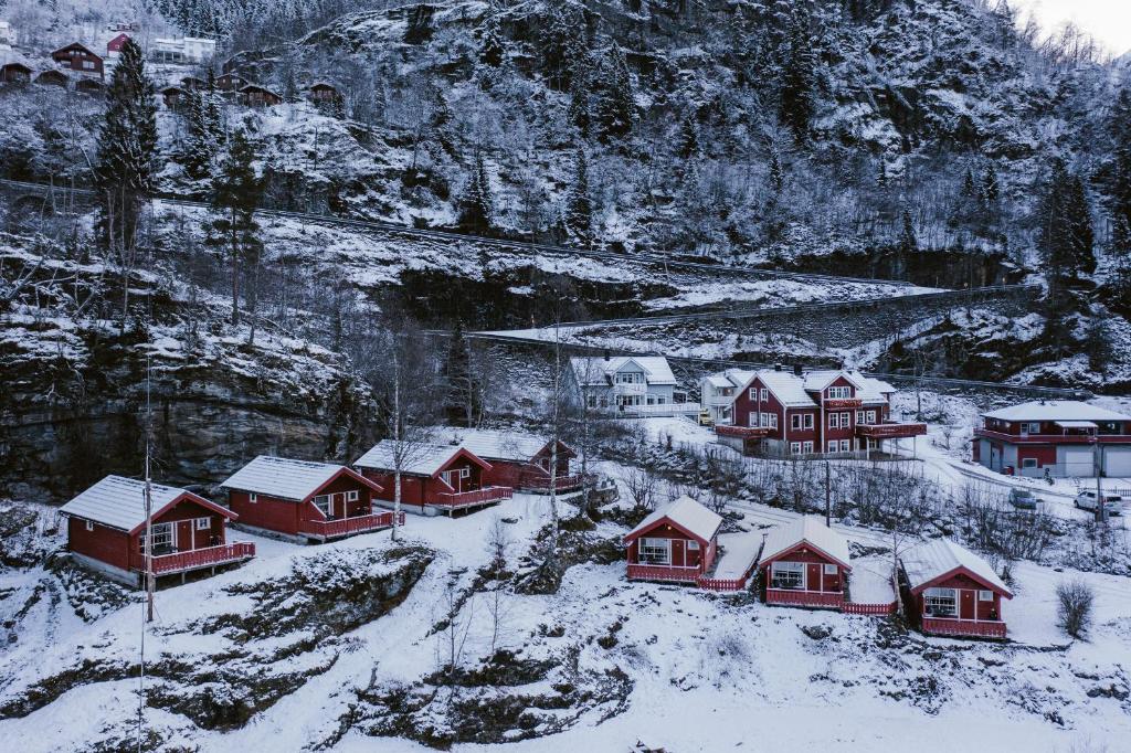 a group of houses covered in snow on a mountain at Vinje Camping in Geiranger