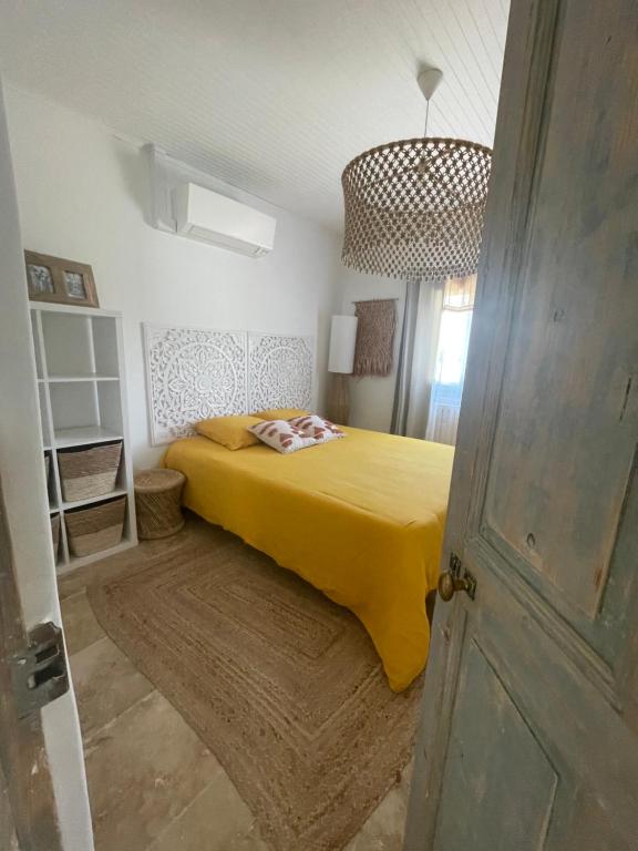 um quarto com uma cama com um cobertor amarelo em Entre les Alpilles et le Luberon 3 chambres 10 pers em Cavaillon