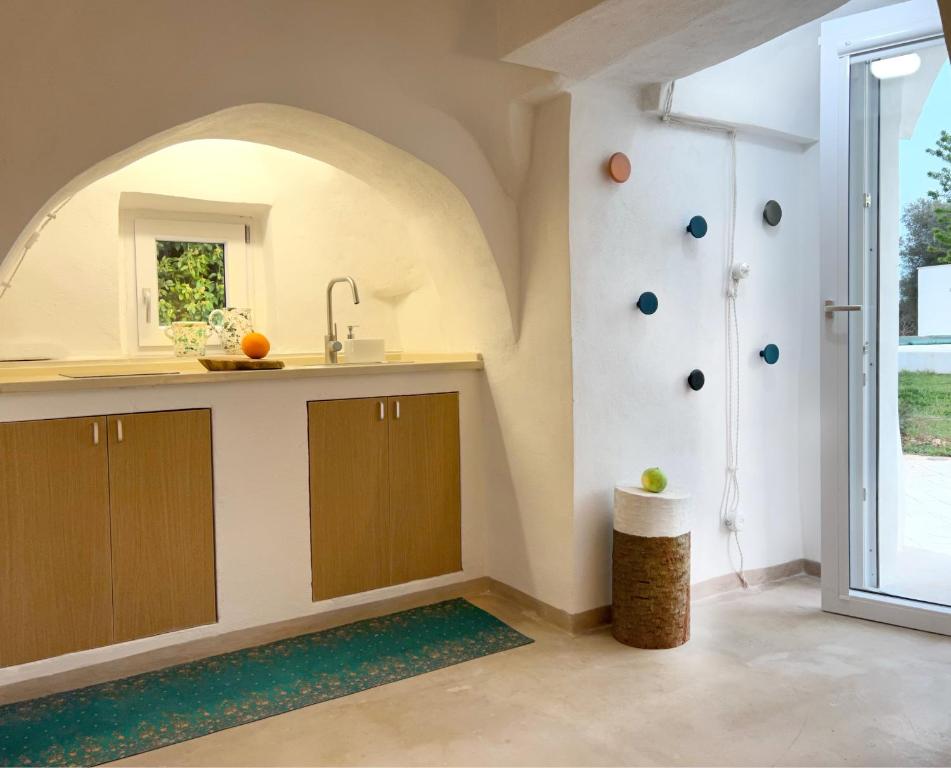 eine Küche mit Spüle und Theke mit Fenster in der Unterkunft VITA VIVET TRULLO in San Michele Salentino