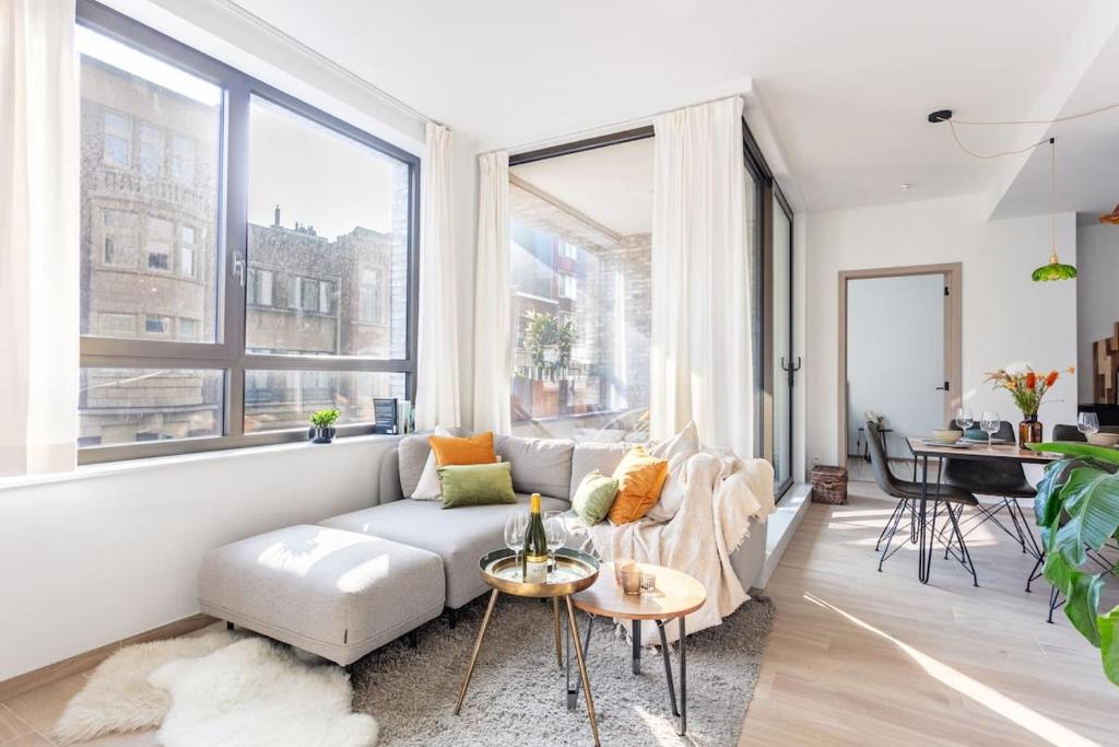 een woonkamer met een bank en een tafel bij Deluxe apartment suite with terrace in Antwerpen