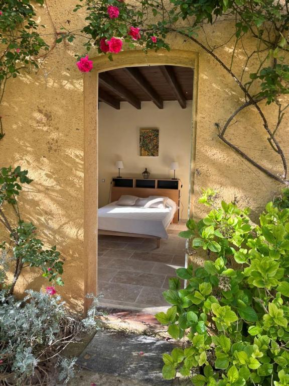 ein Schlafzimmer mit einem Bett in einer Tür mit Blumen in der Unterkunft Charmante petite maison avec piscine in Monguillem