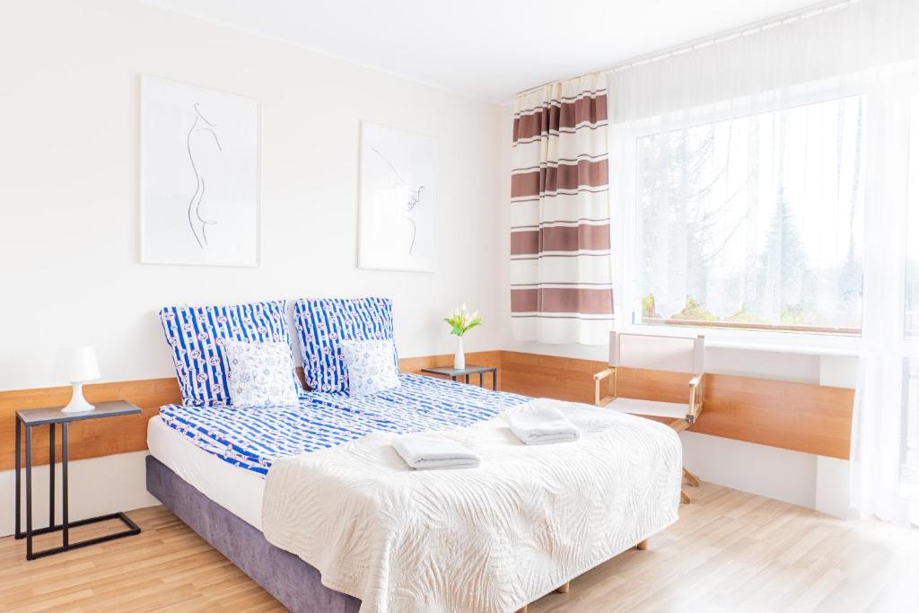 Habitación blanca con cama y ventana en Pokoje Gościnne Raf-Tur - Sala Zabaw, Grill - Idealny dla rodzin z dziećmi en Ostrowo