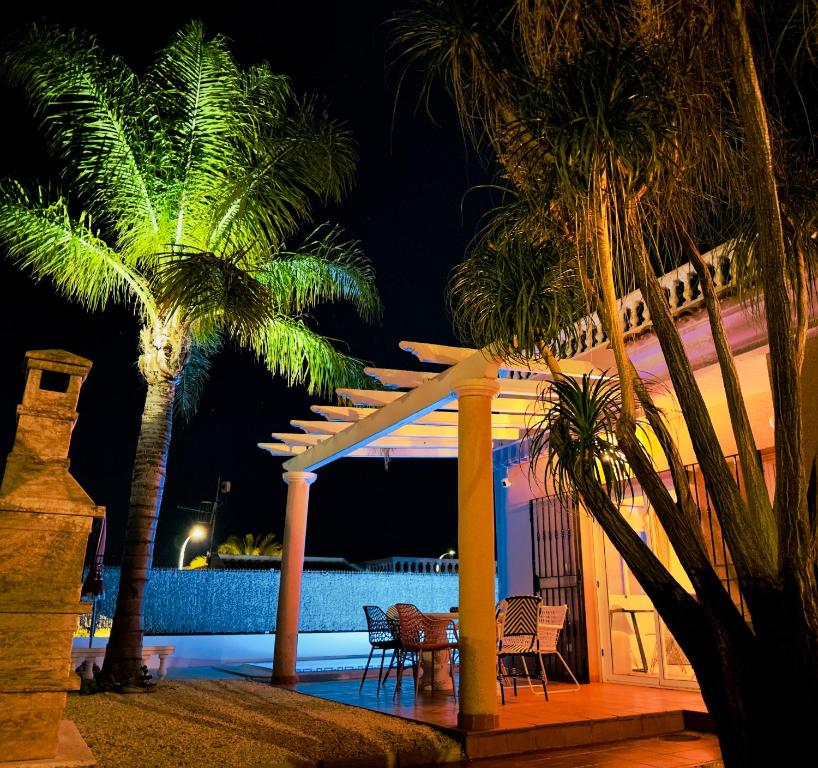 un complejo con palmeras y piscina por la noche en 2 bedroom villa with private swimming pool, en San Juan de los Terreros