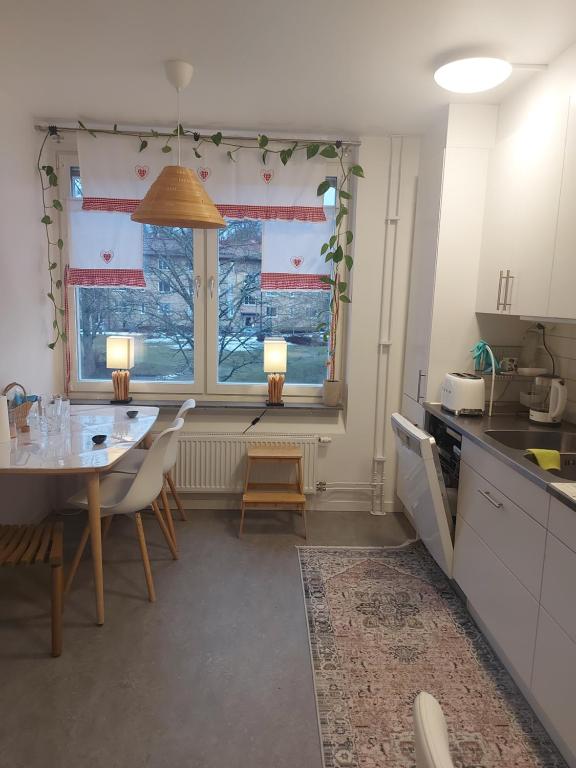 uma cozinha com mesa e cadeiras e uma janela em feel like your own home em Linköping