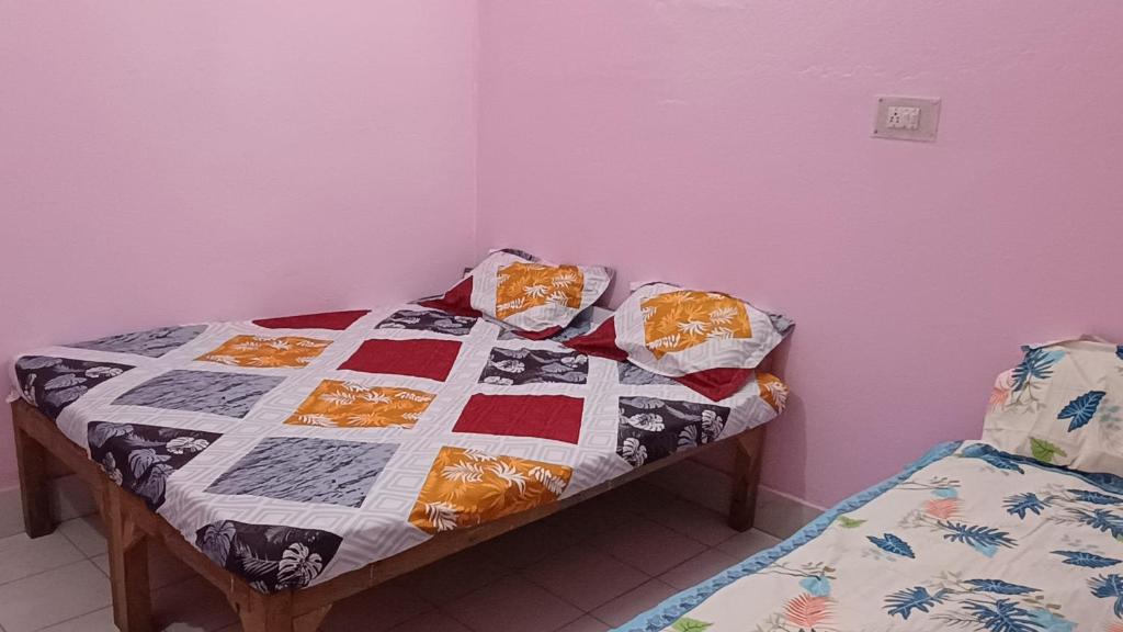 un letto con una trapunta in una stanza di Hotel vikash a Barkot