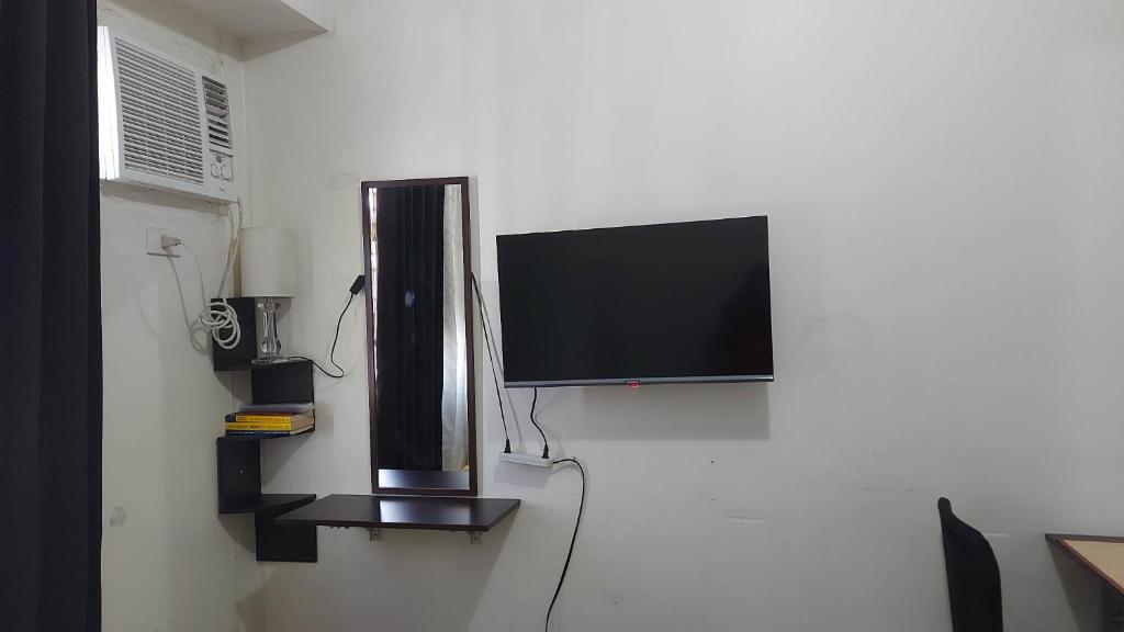 馬尼拉的住宿－Zafreen Staycation/CONDOTEL，挂在墙上的平面电视