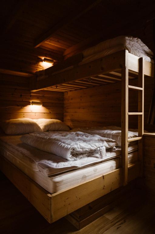 a wooden bunk bed with a ladder in a room at Vinje Camping in Geiranger