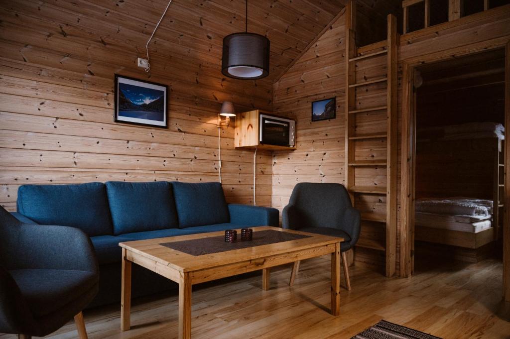 a living room with a blue couch and a table at Vinje Camping in Geiranger
