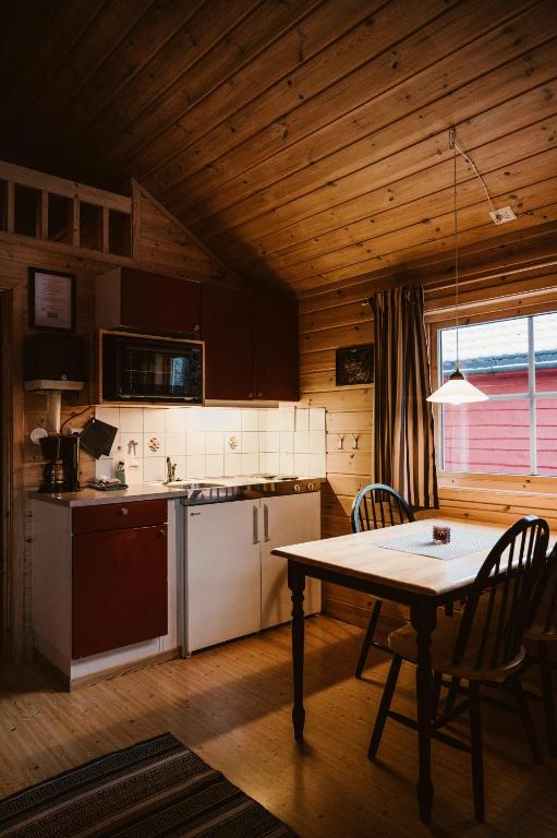 a kitchen and dining room with a table and a table and chairs at Vinje Camping in Geiranger