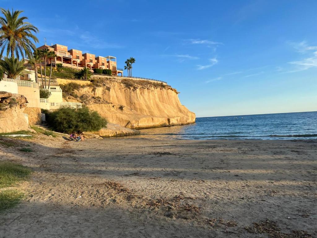 a beach with houses on a cliff next to the ocean at The three bedrooms Casa Barta - 300m from the beach with a beatiful see view from the terrace and private parking in San Juan de los Terreros