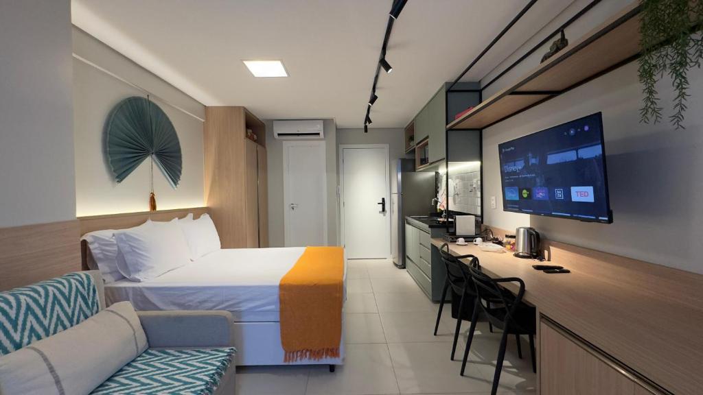 um quarto de hotel com uma cama, um sofá e uma secretária em Barra Premium residencial em Salvador