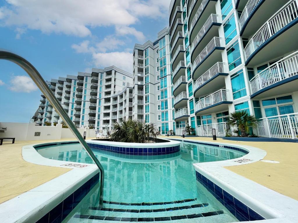 una piscina frente a un gran edificio de apartamentos en The Horizon at 77th, en Myrtle Beach