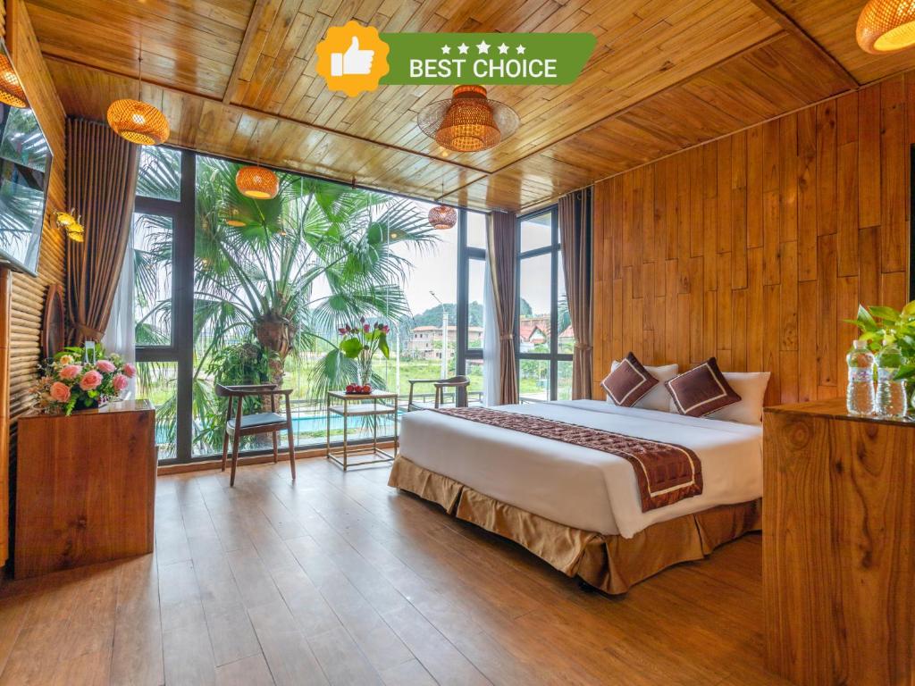 a bedroom with a bed in a room with windows at Tam Coc Serenity Hotel & Bungalow in Ninh Binh