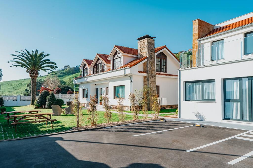una casa con un estacionamiento delante de ella en Villas de La Ribera, en Suances