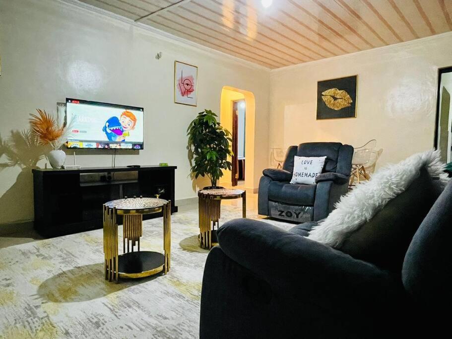 uma sala de estar com um sofá e uma televisão em Mancave em Eldoret