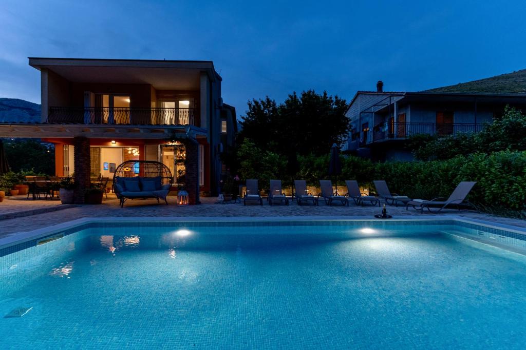 a swimming pool in front of a house at House with pool Garden in Žrnovnica