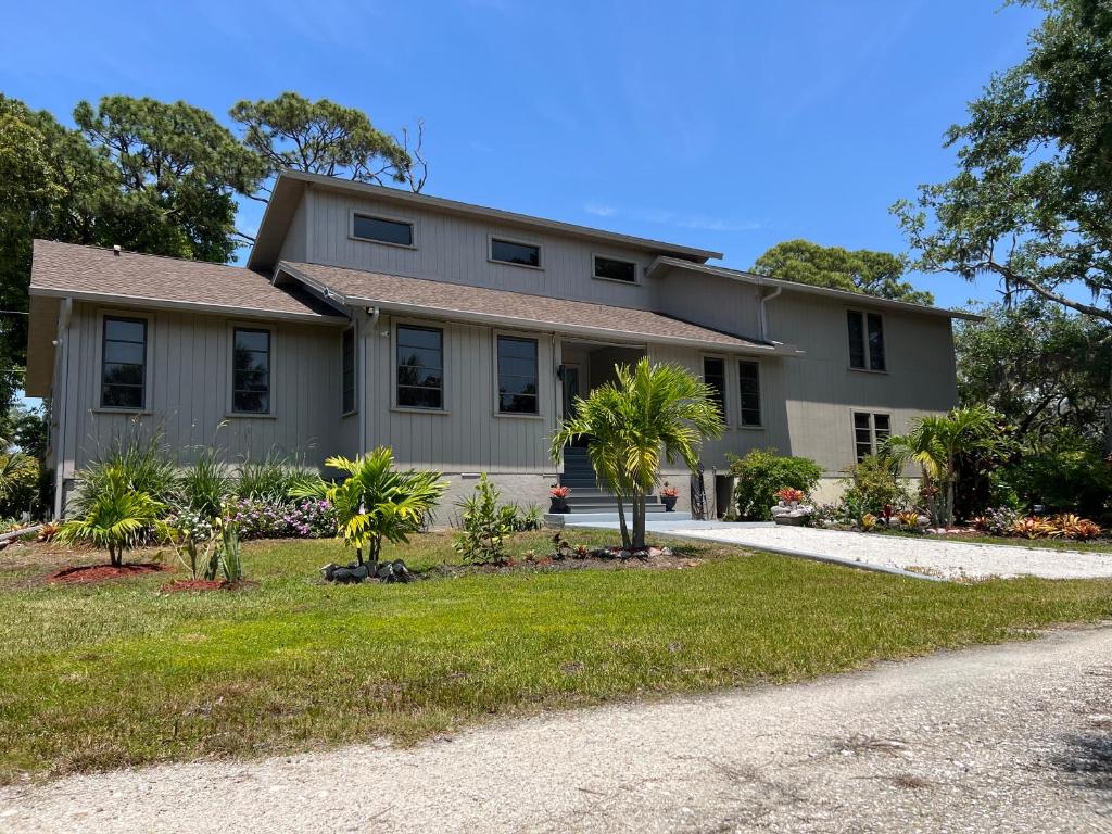 a house with palm trees in front of a driveway at tropical bay house in Englewood