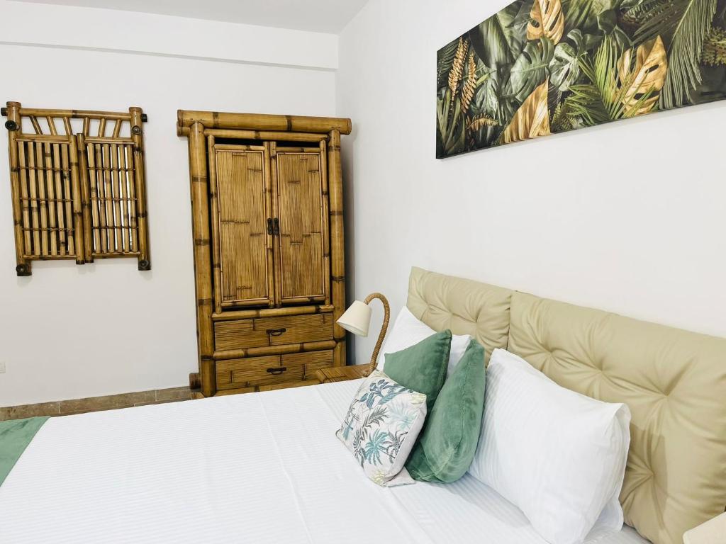 a bedroom with a bed and a wooden cabinet at Holidays Makerel Lodge Vibes Mamaia Nord in Mamaia Nord