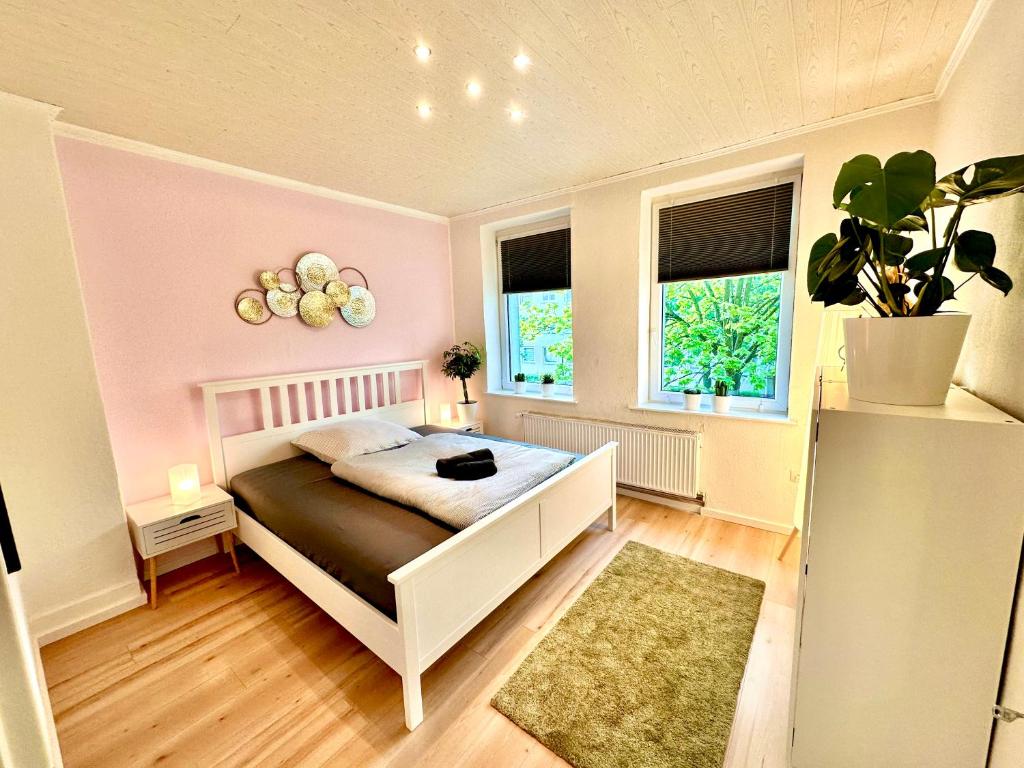 a bedroom with a white bed and a pink wall at Akram Appartement IV - Nähe Bahnhof in Hildesheim