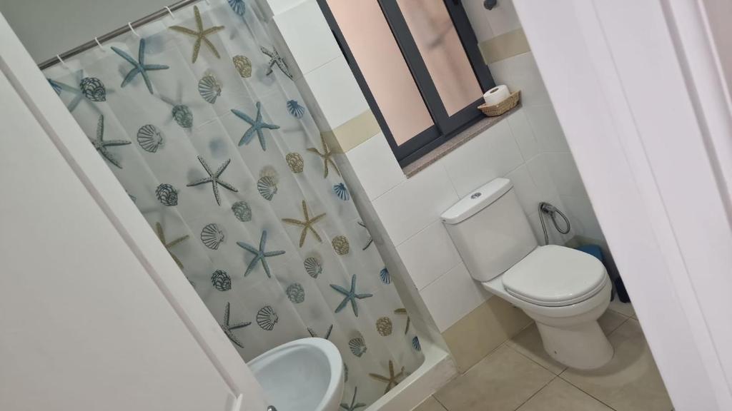 a bathroom with a toilet and a shower curtain at St Julian's Central Paceville Apartments in St Julian's
