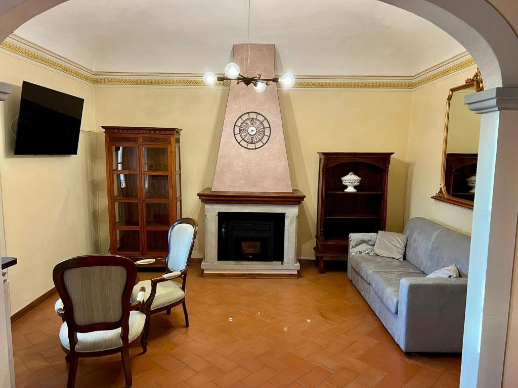un soggiorno con divano e camino con orologio di LE VOLTE centro storico di Poppi a Poppi