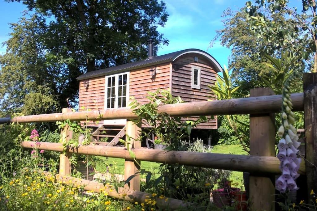 uma pequena cabina de madeira num campo com uma cerca em Duck Hut em Dundon