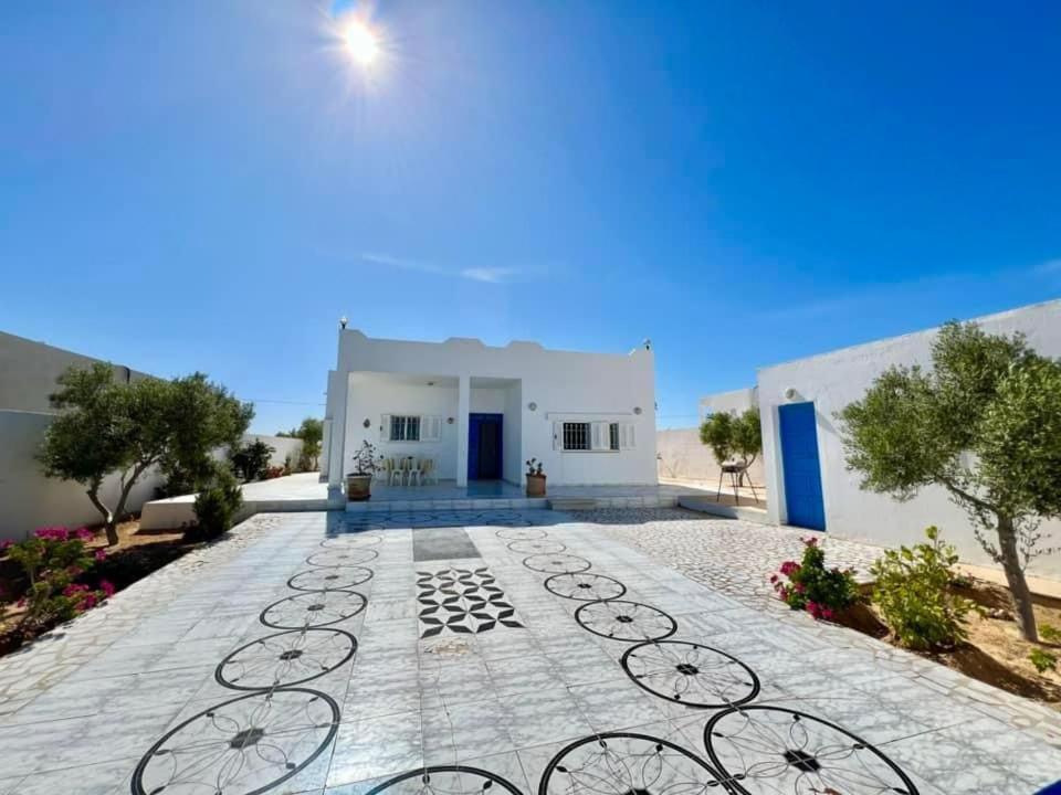 a white building with a pathway in front of it at Villa Yasmine in Djerba