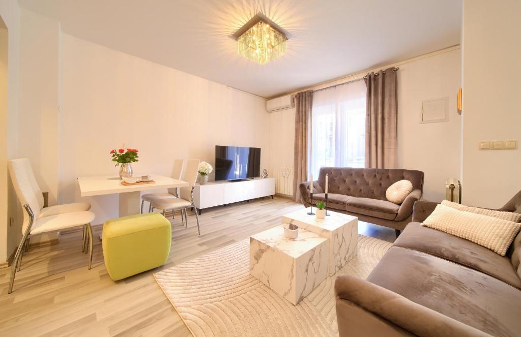 a living room with a couch and a table at Apartmani ASSA Krk in Krk