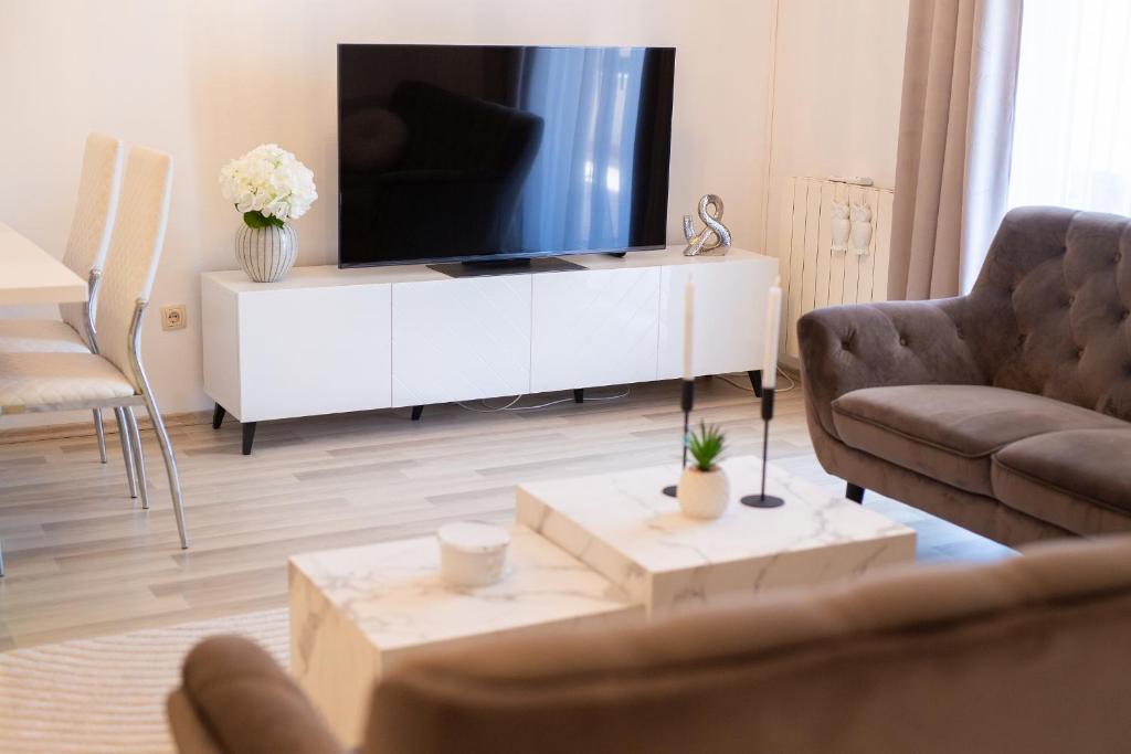 a living room with a television on a white cabinet at Apartmani ASSA Krk in Krk