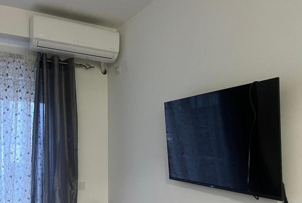 Une télévision à écran plat est installée sur un mur à côté d'une fenêtre. dans l'établissement Studio MERAKI, à Dojran