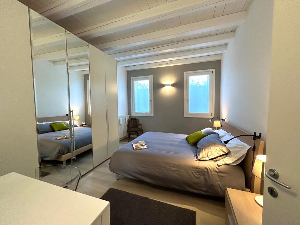 una camera con un grande letto e uno specchio di Soranza Suite a Castelfranco Veneto