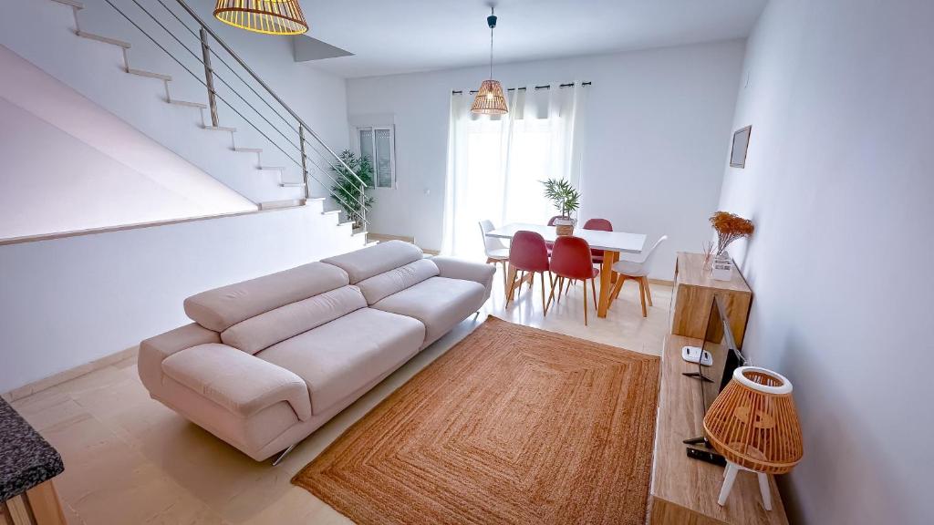 uma sala de estar com um sofá branco e uma mesa em Alojamientos Claus em Almodóvar del Río