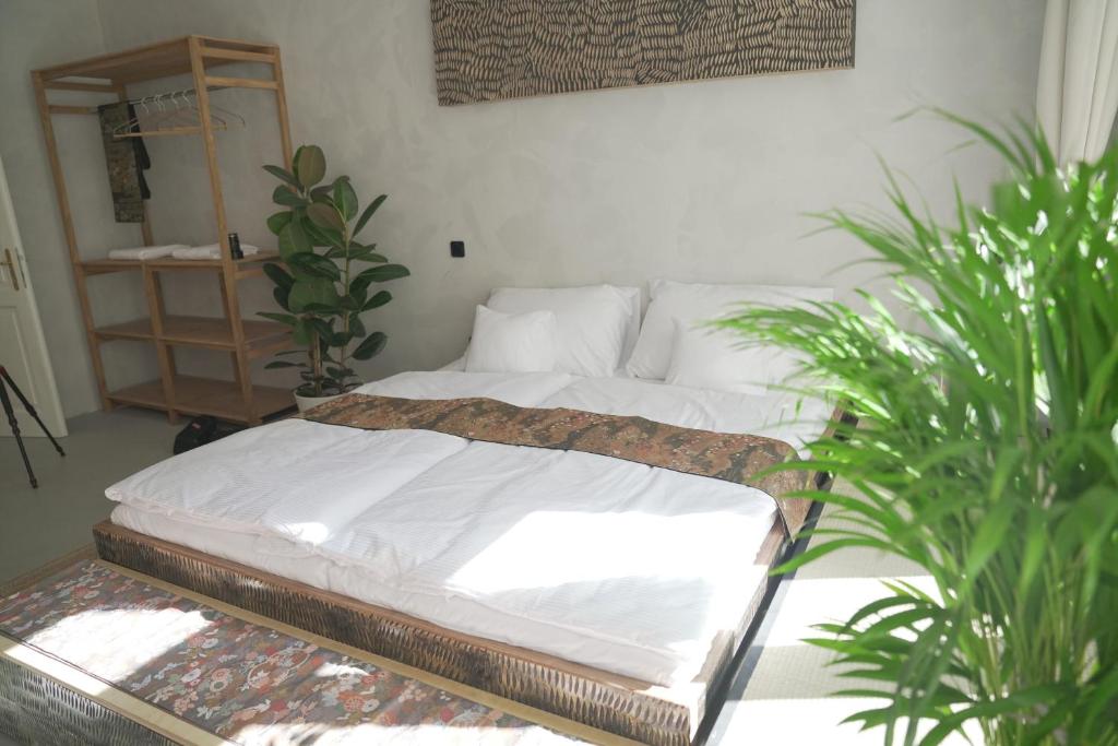 プラハにあるArt hotel Sazavskaの鉢植えの植物2本が備わる部屋のベッド1台