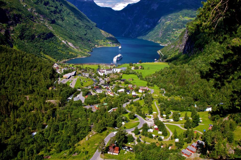 an aerial view of a village in a valley with a lake at Vinje Camping in Geiranger