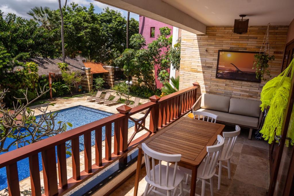 een balkon met een tafel en stoelen en een zwembad bij Apartamento de Charme no Cumbuco - Condomínio Jardim Reale in Caucaia