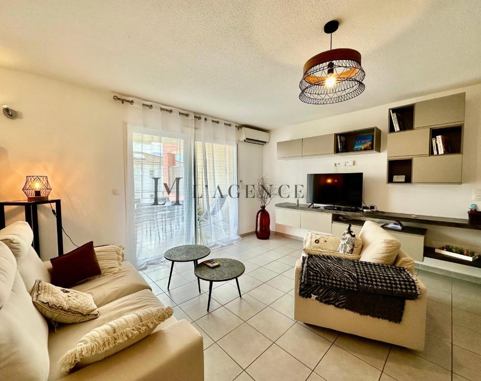 un salon avec un canapé et une table dans l'établissement Appartement Cardellu Paisible & centre-ville CALVI, à Calvi